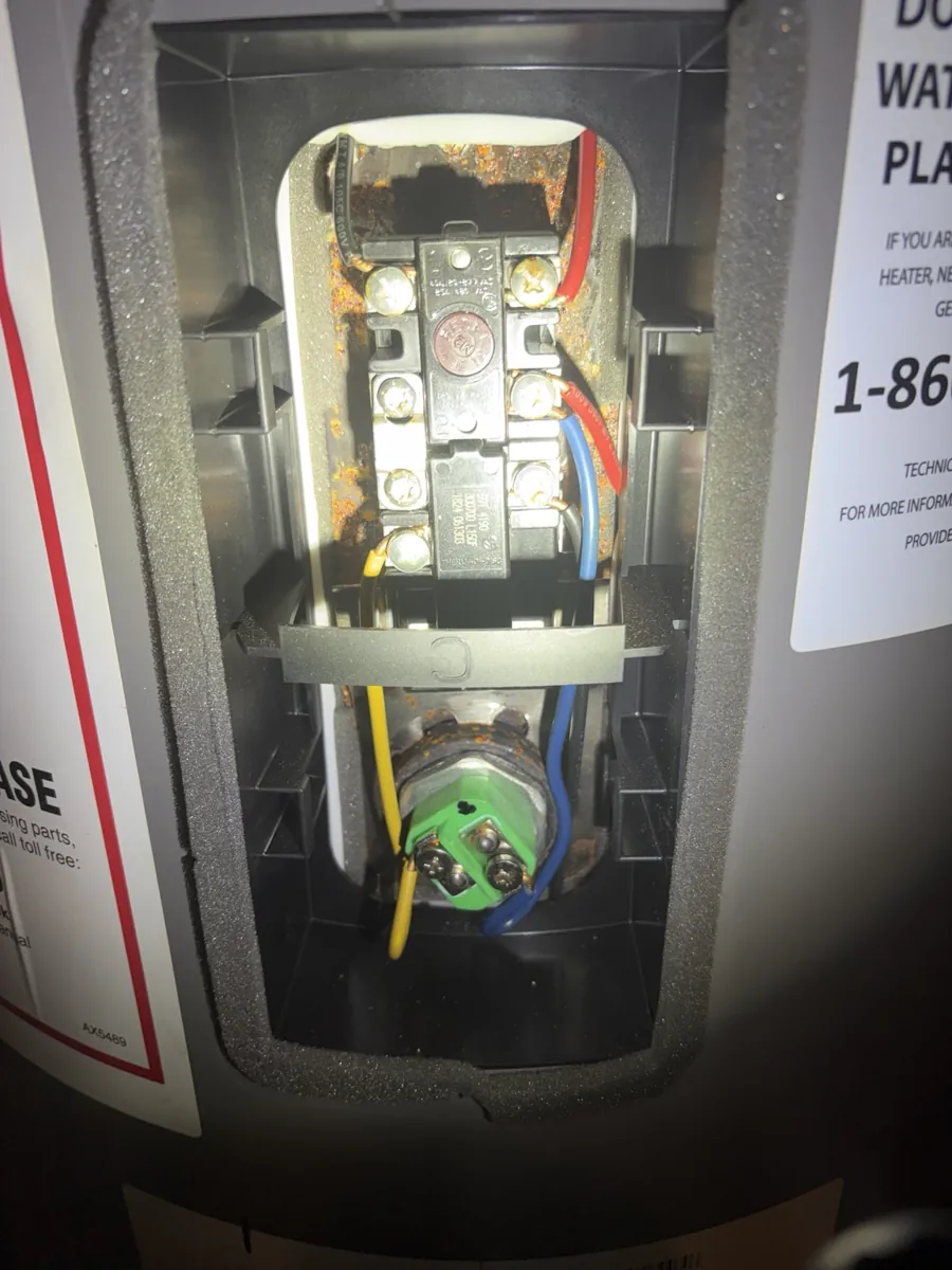 Electric water heater during service: thermostat and element access.